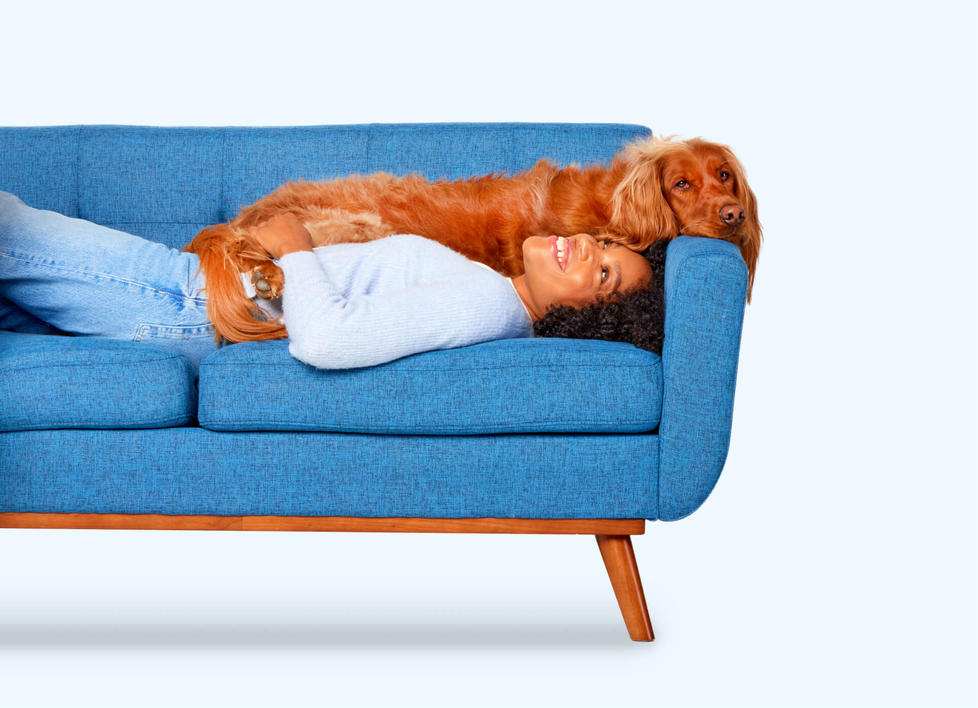 Photo of black woman laying on couch with dog laying on top of her.